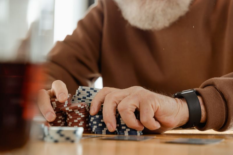 Pemain-pemain sedang memegang kartu poker di meja hijau